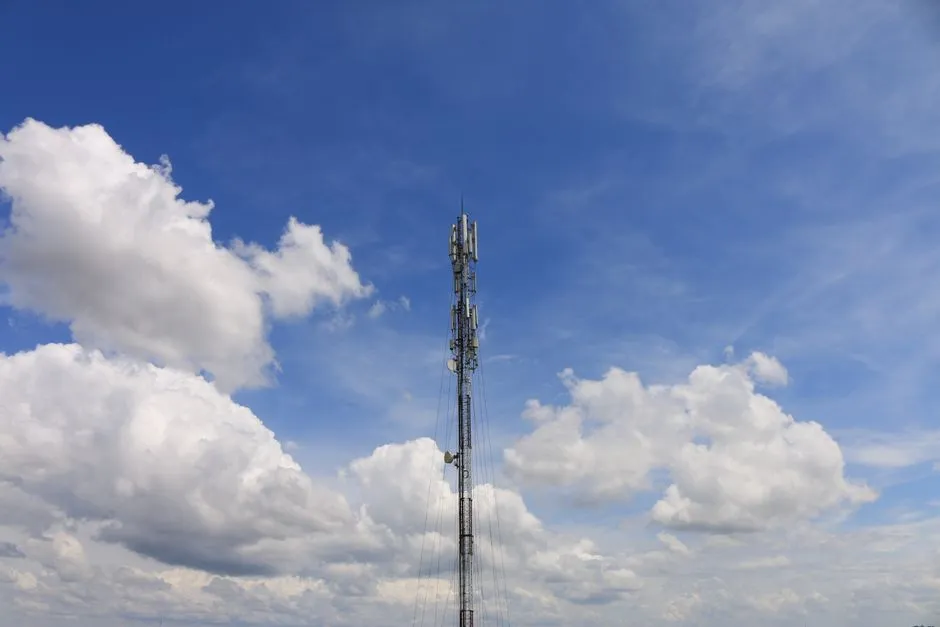 Telecommunications tower against a blue sky with clouds